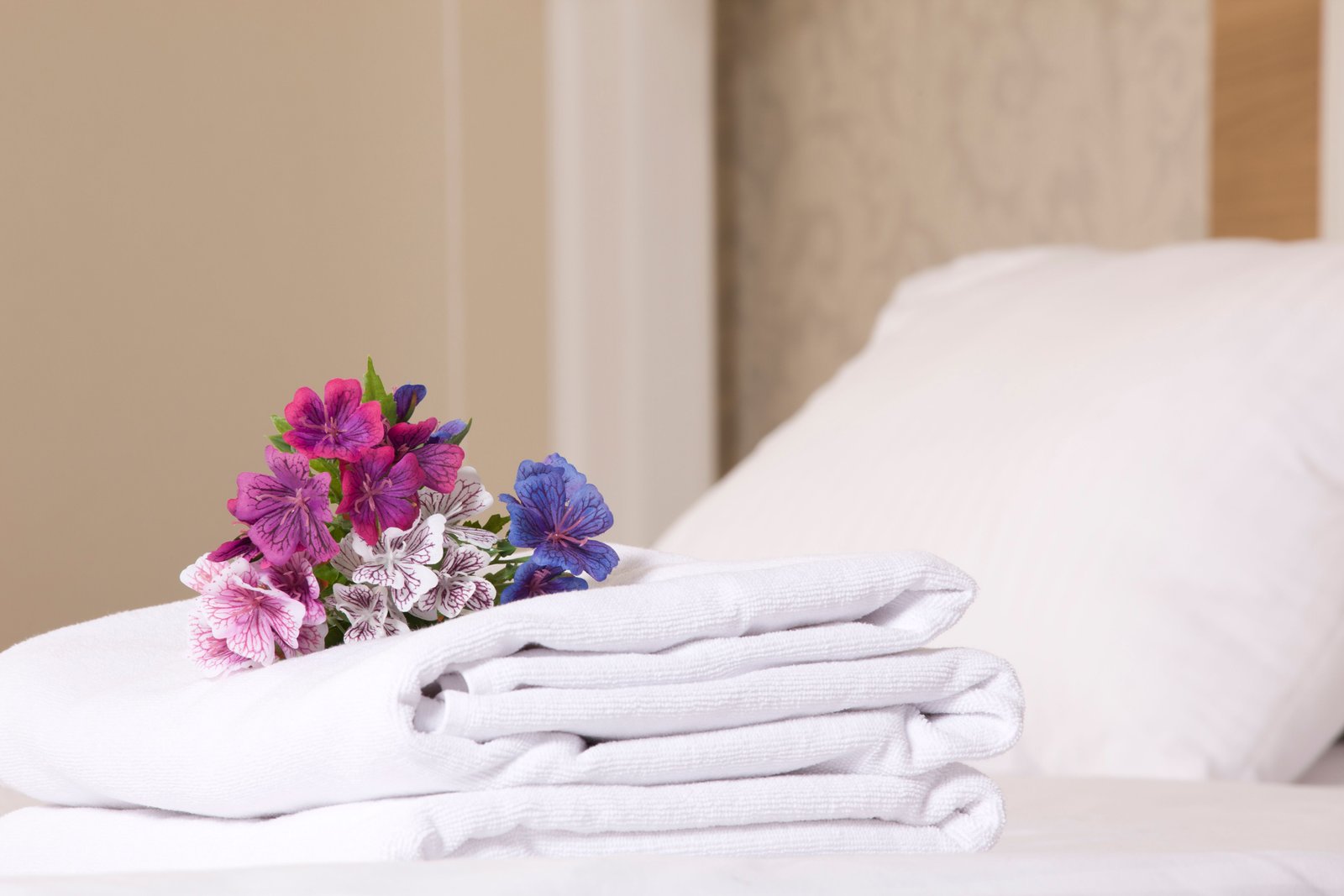 Folded white towels arranged beside flowers.